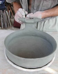 Once the shape has been achieved, handles and grips are added; these are often particularly elaborate in the case of terramare pottery.
