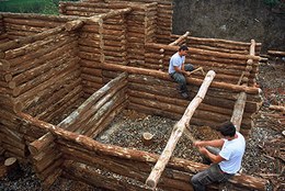 Building the entrance and the village fortifications: notice the wooden cages filled with earth.